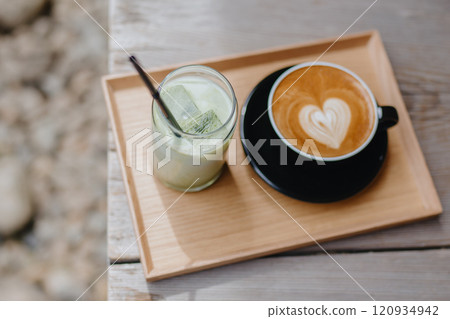Cappuccino coffee and iced green matcha latte tea on tray at outdoor cafe in Kyoto. Morning drinks Cappuccino coffee and iced green matcha latte tea on tray at outdoor cafe in Kyoto. Morning drinks 120934942