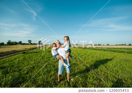 Dad having fun with pretty daughters in nature on sunset. 120935453