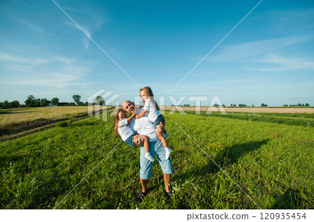 Dad having fun with pretty daughters in nature on sunset. Dad having fun with pretty daughters in nature on sunset. 120935454