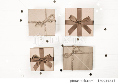 Four beautifully wrapped gift boxes with ribbons and natural twine decor 120935831