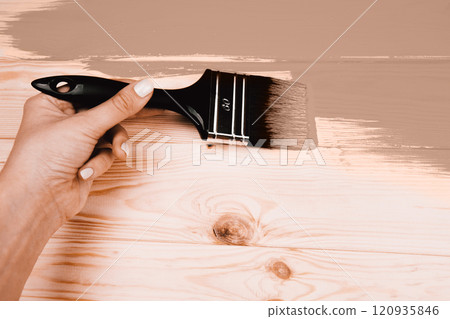 Hand painting wooden surface with a brush in warm tones 120935846