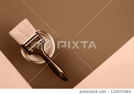 Paintbrush resting on a can against a mocha and mousse background 120935864