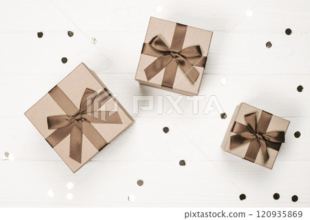 Three elegant gift boxes with brown ribbon on a white background Three elegant gift boxes with brown ribbon on a white background 120935869