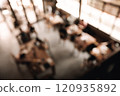 Blurred view of a cozy cafe interior with warm lighting and wooden tables 120935892