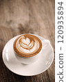 Elegant cappuccino with latte art in a white cup on wooden table 120935894