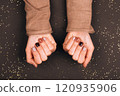 Hands with trendy nail polish featuring shades of mocha and brown tones 120935906