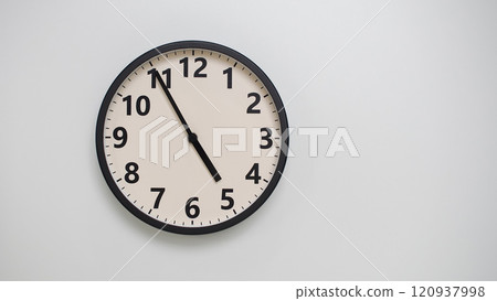 Classic Black-Edged Clock on White Background at 16.55/04.55 - Perfect for Time Management and Text Space 120937998