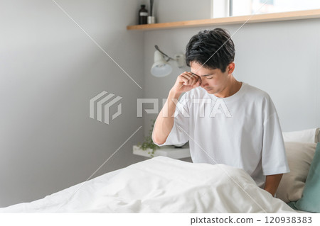 一名年輕人早上在臥室醒來（困倦、睡眠不足、睡眠障礙、失眠、嗜睡、疲勞、發作性睡病） 120938383