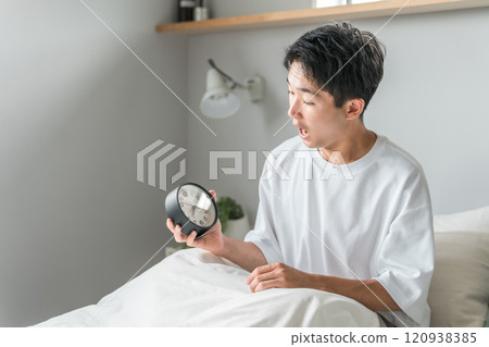 A man wakes up in the morning after looking at the alarm clock (sleep, wakefulness, sleep) 120938385