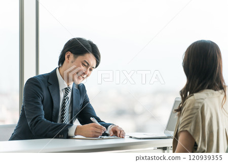 A businessman having an interview and a woman being interviewed A businessman having an interview and a woman being interviewed 120939355