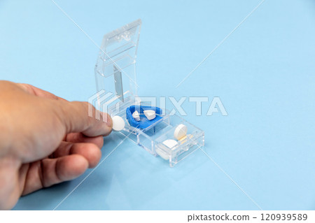 Senior man using pill splitter or pill cutter. Senior man using pill splitter or pill cutter. 120939589