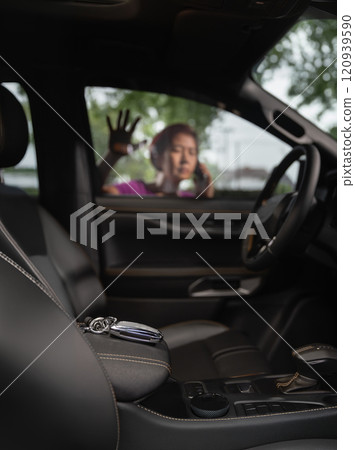 Senior asian woman forgot her key inside locked car. 120939590