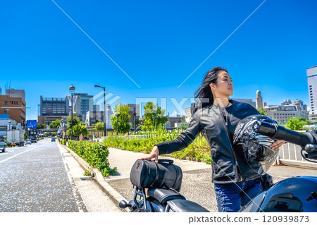 A female rider touring Yokohama on a cruiser bike 120939873