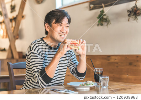 中年男子在咖啡館/餐廳吃漢堡/垃圾食品 120939968