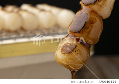 Mitarashi dango: Grilled dumplings dipped in sauce 120940454