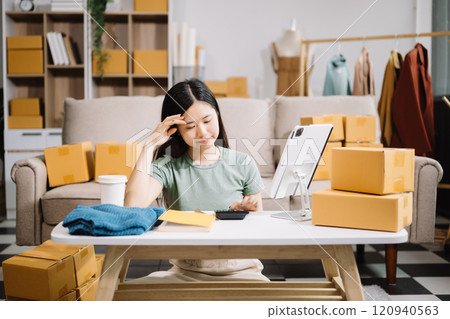 Asian owner woman prepare parcel box  woman is stressed, bored, and overthinking from working and standing check online orders for deliver to customer. 120940563