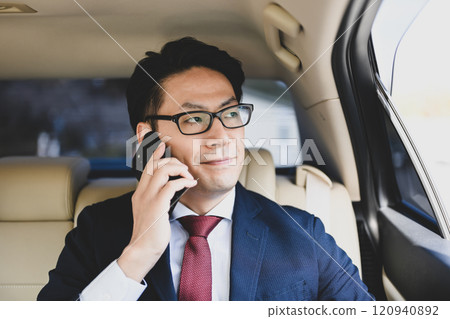 坐在後座用智慧型手機交談的商人 120940892