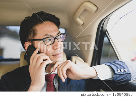 坐在後座用智慧型手機交談的商人 120940893