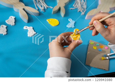 Master class of coloring Creator is using white air dry clay for making decor to EASTER holiday. Creating hobby recreation activity that involves fingers. DIY crafting Master class of coloring Creator is using white air dry clay for making decor to EASTER holiday. Creating hobby recreation activity that involves fingers. DIY crafting 120941080