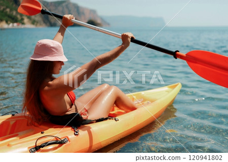 Kayak sea woman. Happy attractive woman with long hair in red swimsuit, swimming on kayak. Summer holiday vacation and travel concept. 120941802