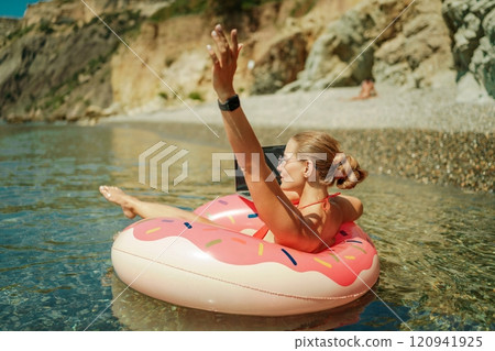 Woman laptop sea. Freelancer woman in sunglases floating on an inflatable big pink donut with a laptop in the sea. People summer vacation rest lifestyle concept Woman laptop sea. Freelancer woman in sunglases floating on an inflatable big pink donut with a laptop in the sea. People summer vacation rest lifestyle concept 120941925