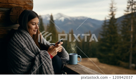 Cozy mountain retreat with woman relaxing and enjoying coffee with scenic view 120942037
