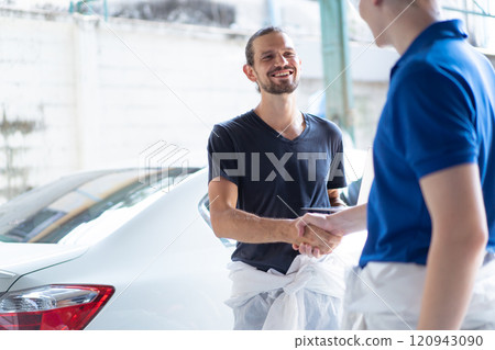 Team of professional automotive painting technician in chemical protecting suit standing in front of the painting chamber together. Car painting and detailing technicians portrait. 120943090