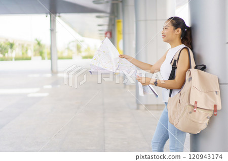 Happy beautiful Asian female backpack traveler explore the city and landmark on a map, woman backpacker tourist looking - exploring the city street on a map. 120943174
