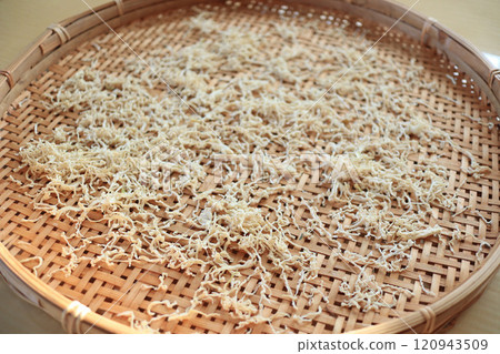 Making dried daikon strips using a colander Making dried daikon strips using a colander 120943509