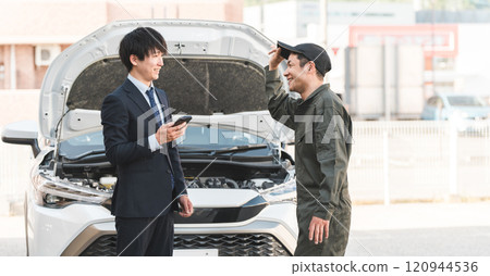 A male worker and a male driver rushed to the road for road service. A male worker and a male driver rushed to the road for road service. 120944536