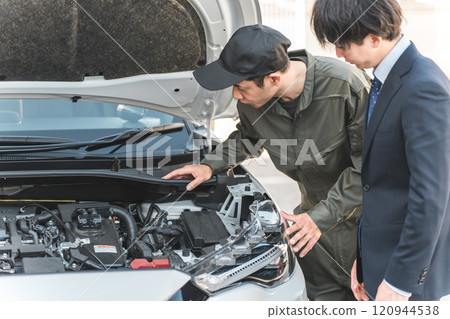 男機械人員在汽車引擎室向司機解釋 120944538