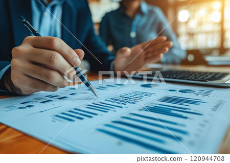 Business professionals analyzing financial charts and data with pen and laptop Business professionals analyzing financial charts and data with pen and laptop 120944708