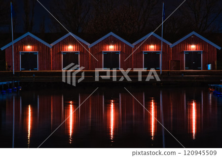 Quiet waterfront at night and illuminated red buildings Quiet waterfront at night and illuminated red buildings 120945509