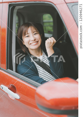 A smiling young woman in a car gives a thumbs up A smiling young woman in a car gives a thumbs up 120946271