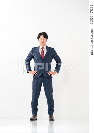 Businessman, male in his 20s, standing with his legs crossed 120947031