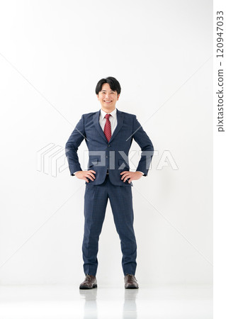 Businessman, male in his 20s, standing with his legs crossed Businessman, male in his 20s, standing with his legs crossed 120947033