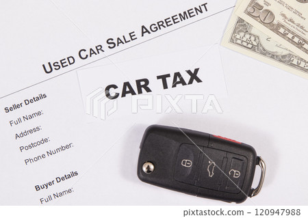Car key, dollar banknotes, inscription car tax and vehicle sales agreement 120947988