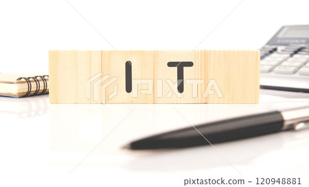 Information technology. IT abbreviation It is written on wooden cubes in a composition with a calculator, pen, notebook on a white background 120948881