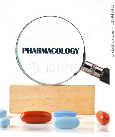 Understanding pharmacology through a magnifying glass with various medication tablets displayed on a wooden surface Understanding pharmacology through a magnifying glass with various medication tablets displayed on a wooden surface 120948912