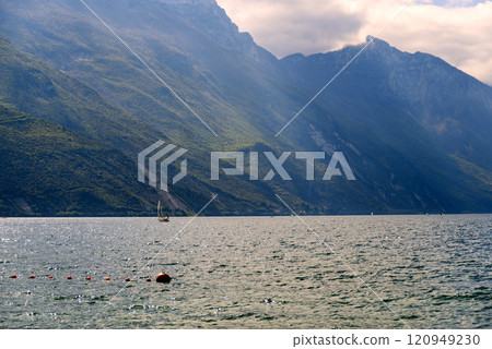 Sailing boats on Garda Lake, beautiful Lake Garda surrounded by mountains Sailing boats on Garda Lake, beautiful Lake Garda surrounded by mountains 120949230