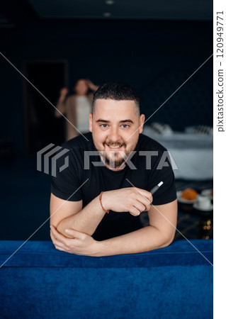 Brunette man in black t-shirt with e-cigarette. Brunette man in black t-shirt with e-cigarette. 120949771