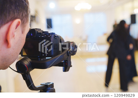 A professional camera on the blurred background of a banquet hall. A professional camera on the blurred background of a banquet hall. 120949829