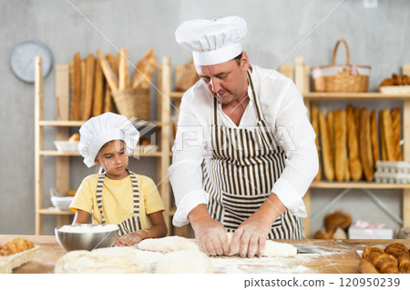 Father and daughter roll out dough together to make delicious bread Father and daughter roll out dough together to make delicious bread 120950239