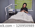 Female Specialist, Skin Health, Female Masseuse. SPF sunscreen is meticulously applied to patient's face by skincare specialist. 120950989