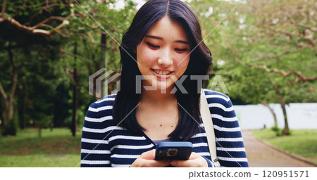 App, phone and walking with woman in park for adventure, sightseeing or travel to explore Japan. App, search for directions or social media with smile of happy tourist person in nature for vacation 120951571