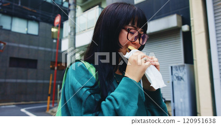 Travel, eating and woman with food in city on vacation, adventure or weekend trip for journey. Happy, pastry and hungry Japanese female person enjoying Taiyaki for lunch in urban town on holiday. 120951638
