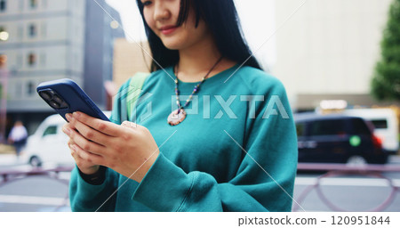 Japanese, woman and commute with phone in city for communication, social media and chat notification. Girl, travel and mobile for navigation app of location, reading blog and website texting in Japan 120951844