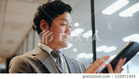 Business, man and typing on tablet in office for portfolio management, funding proposal review or reading info. Japanese firm, budget analyst and digital technology for contract agreement or planning 120951995