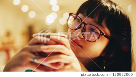 Woman, coffee and thinking in cafe with glasses, relax or study break at night with bokeh. Japanese student, matcha drink or daydream in Tokyo restaurant with peace, green tea or calm with reflection 120952060