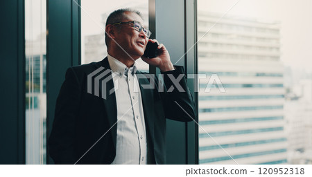 Japanese, businessman and office with phone call for communication, planning or networking by window. Thinking, male person and mature lawyer with mobile for talking, smile and case detail for client Japanese, businessman and office with phone call for communication, planning or networking by window. Thinking, male person and mature lawyer with mobile for talking, smile and case detail for client 120952318